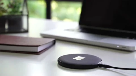 Smart phone being charged on wireless charger alongside with laptop, glasses Stock-Footage 156047294