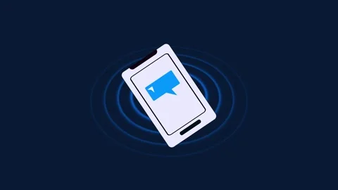 Smart phone displaying a blue speech bubble icon with radiating waves on a .. Stock Footage 332992156