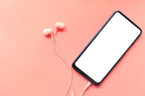 Smart phone with empty screen, earphone on pink background Stock Photos
