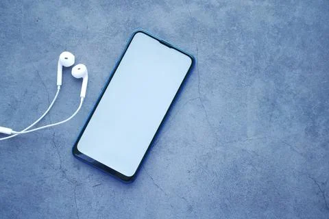 Smart phone with empty screen, earphone on black background Stock Photos