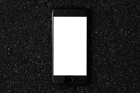 Smart phone flat lay on a black sand with empty screen Stock Photos