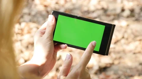 Smart phone with green screen display  in nature close-up  Stock Footage 56434079
