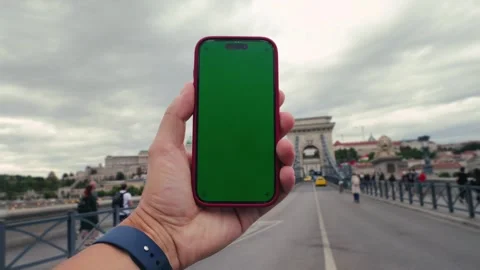 Smart phone green screen in hand on urban background. Walk with phone Stock Footage 324099404