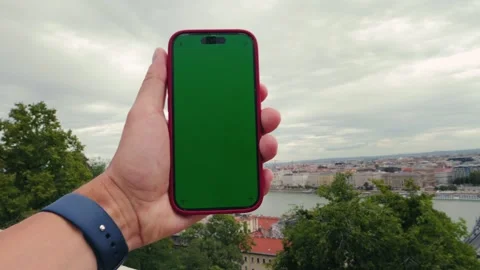 Smart phone green screen in hand on river and urban background. Walk with phone Stock Footage 326484730