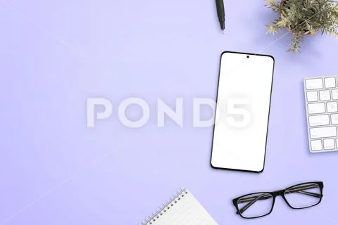 Smart phone with isolated screen for mockup on purple desk surrounded by glasses PSD Template