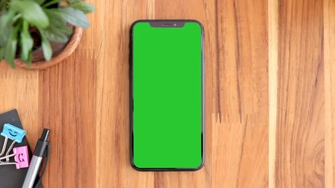 Smart phone place on table wood with green screen Stock Footage