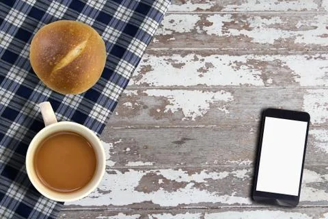 Smart phone on table with bread and coffee Stock Photos