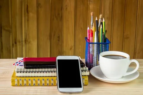 Smart phone,coffee cup,and stack of book with calendar on wooden table Foto stock