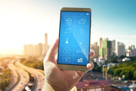 Smart remote home control system apps on a hand phone with out of focus citys Stock Photos