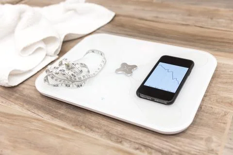Smart scale standing on a floor connected to smartphone Stock Photos