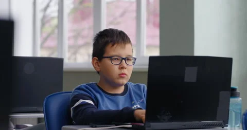 Smart Schoolboy With Eyeglasses Working With Laptop In Modern Computer-Based Stock Footage 280172403