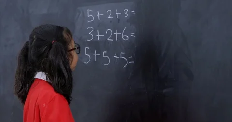 Smart schoolgirl solving a math problem Stock Footage 86991745