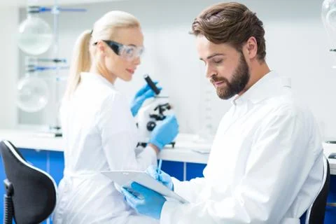 Smart serious scientist taking notes Stock Photos