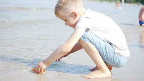 Smart Small boy Playing on Beach in Water on a Sunny Day. Slow Motion shot.  Stock Footage 133937870