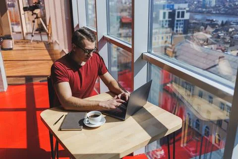 Smart software developer sitting at desktop in coworking space with laptop an Stock Photos