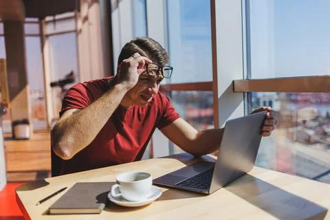 Smart software developer sitting at desktop in coworking space with laptop an Stock Photos