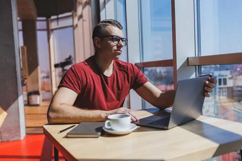 Smart software developer sitting at desktop in coworking space with laptop an Stock Photos