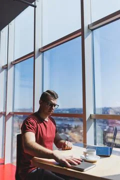 Smart software developer sitting at desktop in coworking space with laptop an Stock Photos