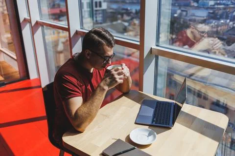 Smart software developer sitting at desktop in coworking space with laptop an Stock Photos