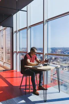 Smart software developer sitting at desktop in coworking space with laptop an Stock Photos