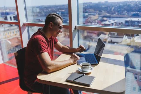 Smart software developer sitting at desktop in coworking space with laptop an Stock Photos