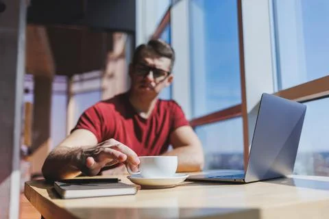 Smart software developer sitting at desktop in coworking space with laptop an Stock Photos