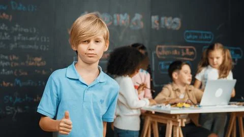 Smart student showing thumb while diverse friend working at board. Erudition. 스톡 사진