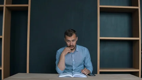 Smart student succeeds as reading a book, attractive young man in glasses Stock Footage 95919723