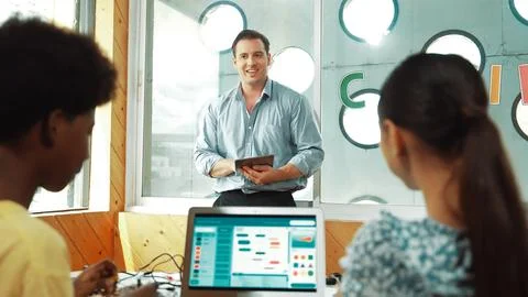 Smart teacher hold tablet while back view student learning code. Edification. Foto stock