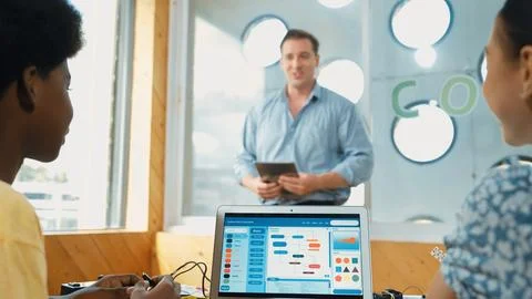 Smart teacher hold tablet while back view student learning code. Edification. Stock Photos