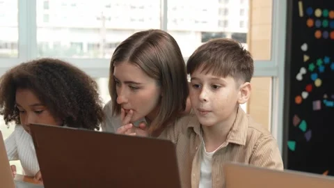 Smart teacher teaching and looking student using laptop at classroom. Erudition. Stock Footage 267039648