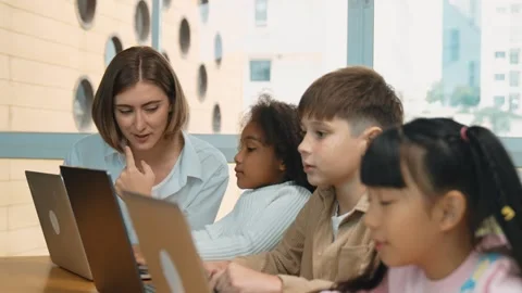 Smart teacher teaching and looking student using laptop at classroom. Erudition. Stock Footage 269616507