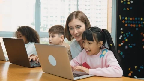 Smart teacher teaching and looking student using laptop at classroom. Erudition. Stock Footage 270458071