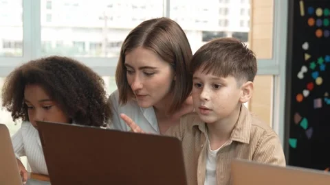 Smart teacher teaching and looking student using laptop at classroom. Erudition. Stock Footage 273669349