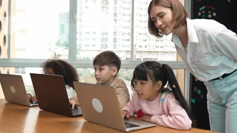 Smart teacher teaching and looking student using laptop at classroom. Erudition. Stock Footage 274364219