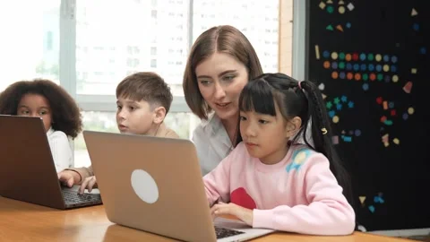 Smart teacher teaching and looking student using laptop at classroom. Erudition. Stock Footage 275804956