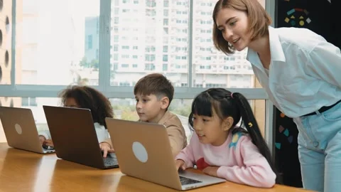 Smart teacher teaching and looking student using laptop at classroom. Erudition. Stock Footage 277416488