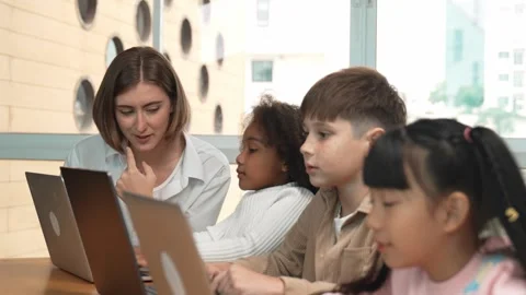 Smart teacher teaching and looking student using laptop at classroom. Erudition. Stock Footage 279594450
