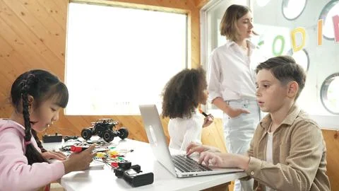 Smart teacher teaching and looking student using laptop at classroom. Erudition. Stock-Fotos