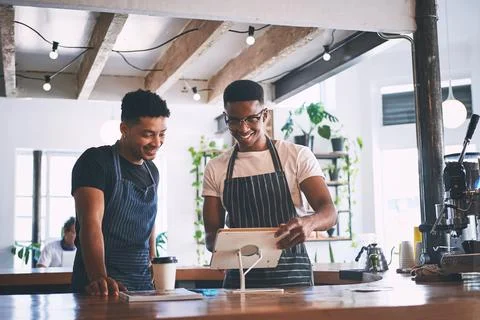 The smart tech that keeps their sales up. two young men using a digital tablet Stock Photos