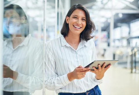 Smart tech makes everything so much simpler. a young businesswoman using a Stock Photos