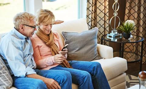 Smart technology just simplifies everything. a mature couple using a phone Stock Photos