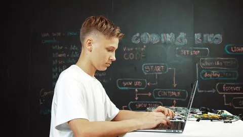 Smart teenager coding or programing system at table with equipment. Edification. Stock Photos