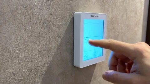 Smart thermostat mounted on textured wall for modern home automation use an.. Stock Footage 336399521