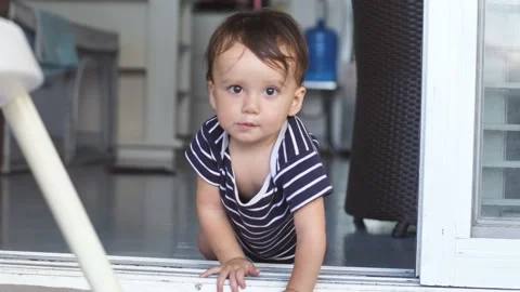 Smart A toddler less than a year old opens the door on his own, climbs over the Stock Footage 172563555