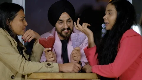 Smart turbaned Sikh with two hear shaped blocks in his hand is asking for option Stock Footage 102374005