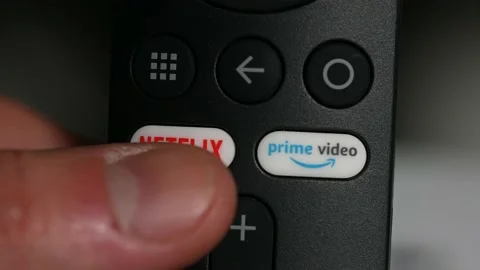 Smart Tv controller with Netflix and Prime video buttons. User is chosing Net Stock Footage 172467052