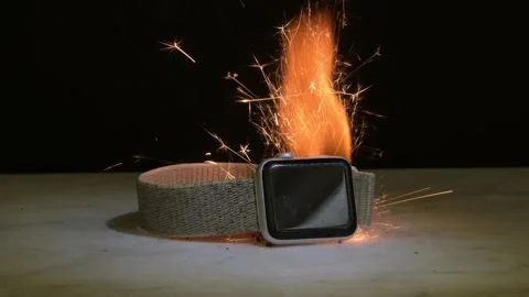 The smart watch caught fire on the table - a massive explosion of battery and sp Stock Footage 309485555