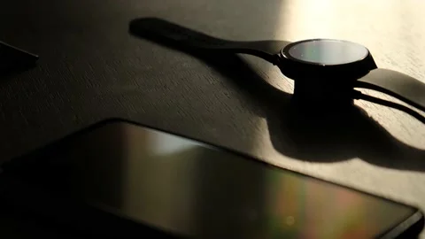 Smart watch is charging from a smartphone on the table, close-up Video stock 230033682