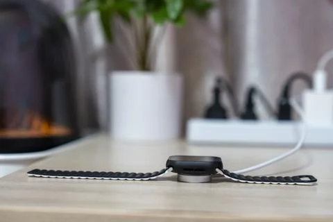 Smart watch is charging on the table Stock Photos